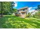 Exterior of a two-story home featuring a well-manicured backyard with a deck and stone patio at 9 Sandhill Ln, Durham, NC 27713
