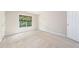 Light-filled bedroom featuring a large window and neutral colored walls and carpet at 9 Sandhill Ln, Durham, NC 27713