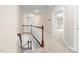 Bright hallway with wood railing and neutral carpet leading to additional bedrooms at 9 Sandhill Ln, Durham, NC 27713