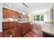 Bright kitchen features granite counters, wood cabinets and flooring, and a functional center island with views through the large window at 9 Sandhill Ln, Durham, NC 27713
