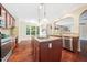 Well-lit kitchen features a center island with granite counters, stainless steel appliances, and beautiful hardwood flooring at 9 Sandhill Ln, Durham, NC 27713