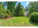 Large grassy backyard with trees surrounding and a fence, perfect for outdoor activities at 9400 Leslieshire Dr, Raleigh, NC 27615