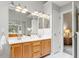 Bright bathroom with double vanity, wood cabinets, and large mirrors, leading to a bedroom view at 9400 Leslieshire Dr, Raleigh, NC 27615