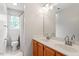 Bright bathroom features a double sink vanity with wood cabinets, framed mirror, and shower-tub combo at 9400 Leslieshire Dr, Raleigh, NC 27615