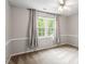 Simple bedroom with carpet, chair rail, fan, and bright windows at 9400 Leslieshire Dr, Raleigh, NC 27615
