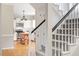 Inviting entryway featuring hardwood floors, a staircase, and a glimpse into the modern, white kitchen at 9400 Leslieshire Dr, Raleigh, NC 27615