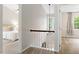 Upstairs hallway showcasing neutral walls, white railing with black accent, and doorway views to rooms at 9400 Leslieshire Dr, Raleigh, NC 27615