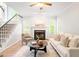 Cozy living room with fireplace, large windows, comfortable seating, and staircase, creating a warm atmosphere at 9400 Leslieshire Dr, Raleigh, NC 27615