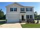 Charming two-story home with a two-car garage, lush lawn, and stone veneer accents at 95 Cordoba Dr, Franklinton, NC 27525