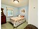 Bedroom featuring a full bed with blue walls and a window for natural light at 96 Holly Cir, Henderson, NC 27537