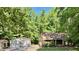 Charming home nestled among mature trees with a detached two-car garage, and stepping stone pathway at 96 Holly Cir, Henderson, NC 27537