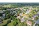 A wide aerial shot reveals a neighborhood with ponds, a golf course, and homes enveloped by lush greenery at 1010 Mill Pointe Way, Elon, NC 27244