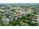 A panoramic aerial shot shows residences amid green spaces and tree cover, with ponds, and a nearby golf course at 1010 Mill Pointe Way, Elon, NC 27244