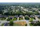 Aerial view showcases a neighborhood with mature trees, manicured lawns, and quiet residential streets at 1010 Mill Pointe Way, Elon, NC 27244