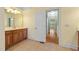 Bathroom with wooden cabinets, tile floors, a mirror, and a doorway at 1010 Mill Pointe Way, Elon, NC 27244