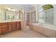 Bathroom features a bathtub, tiled shower, vanity, and a window at 1010 Mill Pointe Way, Elon, NC 27244