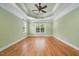 Spacious bedroom with hardwood floors, tray ceiling, ceiling fan, and large windows at 1010 Mill Pointe Way, Elon, NC 27244