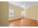 Bedroom with light yellow walls, hardwood flooring, two windows, and a ceiling fan at 1010 Mill Pointe Way, Elon, NC 27244