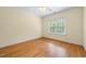 Bedroom with light yellow walls, hardwood flooring, and a large window at 1010 Mill Pointe Way, Elon, NC 27244