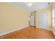 Bedroom with light yellow walls, hardwood flooring, view to the landing and one window at 1010 Mill Pointe Way, Elon, NC 27244
