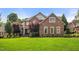 Stunning two-story brick home with a lush green lawn, mature trees, and manicured landscaping at 1010 Mill Pointe Way, Elon, NC 27244