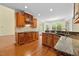 Well-lit kitchen featuring granite countertops, wooden cabinets, and modern appliances at 1010 Mill Pointe Way, Elon, NC 27244
