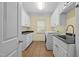 Functional laundry room with white cabinets, dark countertops, and modern washer at 1010 Mill Pointe Way, Elon, NC 27244