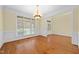 Bright and airy living room with hardwood floors, large windows, and elegant chandelier at 1010 Mill Pointe Way, Elon, NC 27244
