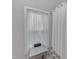 Well-lit bathroom featuring sheer white curtains and a small table and shower at 1011 Burch Ave, Durham, NC 27701