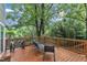Wood deck with seating, table, and view of foliage at 1011 Burch Ave, Durham, NC 27701