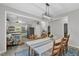 A bright dining room with table set for eight with contemporary chandelier lighting and open to kitchen at 1011 Burch Ave, Durham, NC 27701