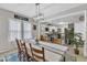 A bright dining room with table set for eight with contemporary chandelier lighting and open to kitchen at 1011 Burch Ave, Durham, NC 27701