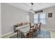 A bright dining room with table set for eight with contemporary chandelier lighting at 1011 Burch Ave, Durham, NC 27701
