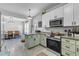 A spacious kitchen featuring modern appliances and stylish green and white cabinetry with eat-in dining at 1011 Burch Ave, Durham, NC 27701