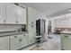 A spacious kitchen featuring modern appliances and stylish green and white cabinetry with eat-in dining at 1011 Burch Ave, Durham, NC 27701