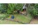 Aerial view of a backyard features mature trees, green lawn, trampoline and screened-in porch at 104 Kylesku Ct, Apex, NC 27502