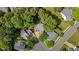 An aerial view of the property nestled among lush trees in a quiet neighborhood at 104 Kylesku Ct, Apex, NC 27502