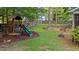 The backyard is great for children with a playhouse and slide as well as stone terraces and landscaping at 104 Kylesku Ct, Apex, NC 27502