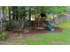 This spacious backyard features a play area, mulch, mature trees and green lawn at 104 Kylesku Ct, Apex, NC 27502