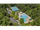 Aerial view of a community pool, tennis courts, and lush green surroundings at 104 Kylesku Ct, Apex, NC 27502