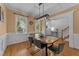 Traditional dining room featuring wood flooring, stylish light fixture, and large windows at 104 Kylesku Ct, Apex, NC 27502