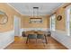 Traditional dining room with wood flooring, stylish lighting, and large windows at 104 Kylesku Ct, Apex, NC 27502