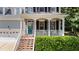 Inviting front porch with white columns, blue front door, and manicured landscaping at 104 Kylesku Ct, Apex, NC 27502