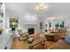 Inviting living room with hardwood floors, a cozy fireplace, and ample natural light at 104 Kylesku Ct, Apex, NC 27502