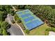 Aerial view of well-maintained tennis and basketball courts surrounded by lush trees at 104 Kylesku Ct, Apex, NC 27502