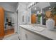 Well-lit bathroom featuring a large mirror, tiled floors, white cabinets, and an adjacent office space at 106 Mill Rock Ct, Carrboro, NC 27510
