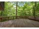 Spacious outdoor wooden deck surrounded by trees and a bench at 106 Mill Rock Ct, Carrboro, NC 27510