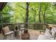 Outdoor deck with seating surrounded by lush, green trees at 106 Mill Rock Ct, Carrboro, NC 27510