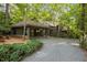 Charming driveway with fresh gravel leading to a home, surrounded by lush landscaping and a convenient carport at 106 Mill Rock Ct, Carrboro, NC 27510