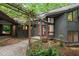 Covered entrance with a wooden deck and pergola with mature landscaping at 106 Mill Rock Ct, Carrboro, NC 27510